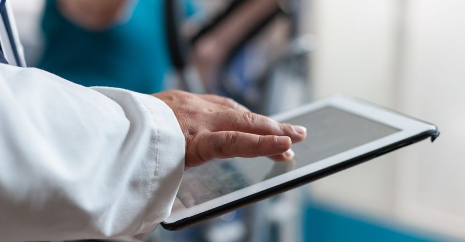 Close up of doctor using digital tablet with touch screen