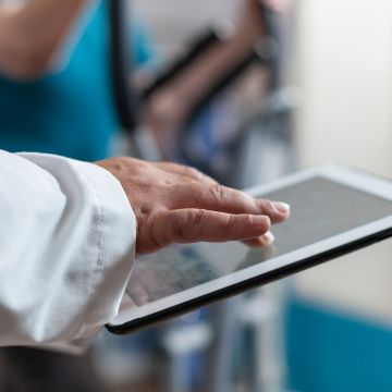 Close up of doctor using digital tablet with touch screen