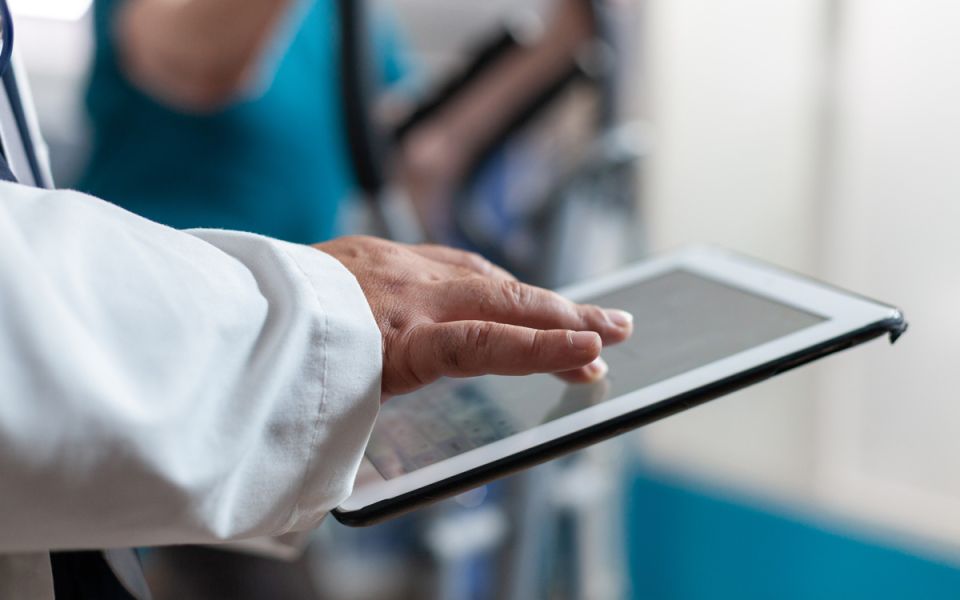 Close up of doctor using digital tablet with touch screen