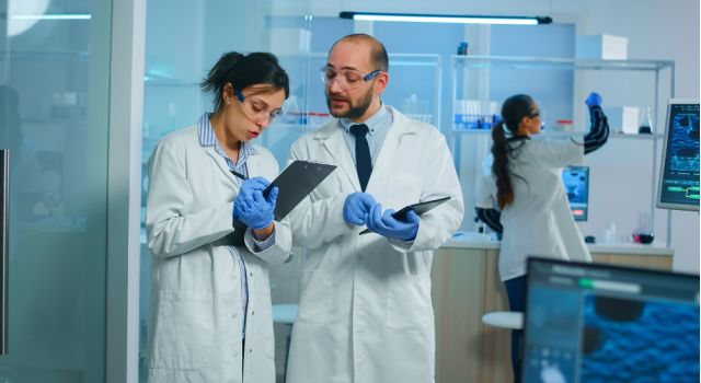 two scientists look over ciplboards