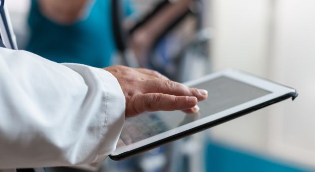 Close up of doctor using digital tablet with touch screen