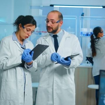 two scientists look over ciplboards