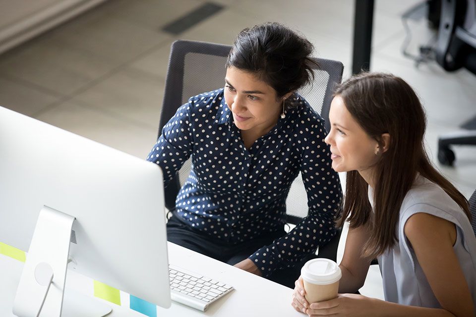 two women work on PC